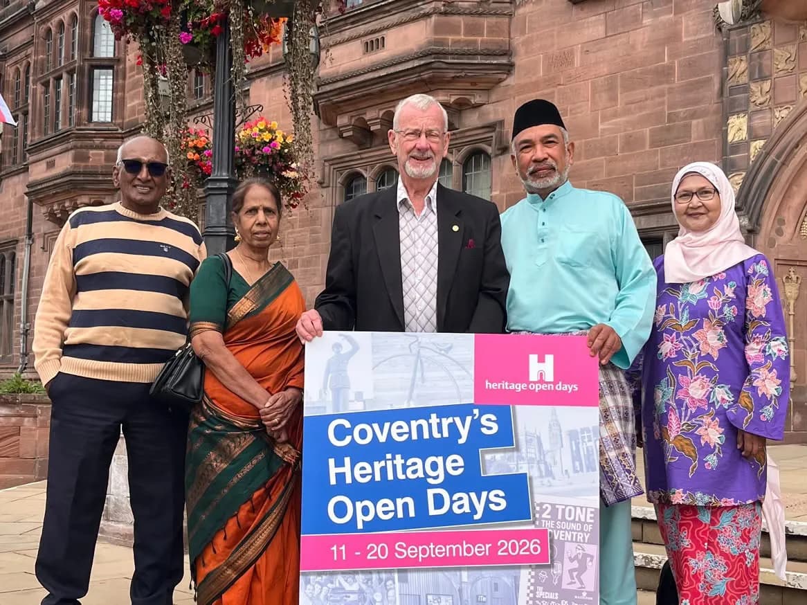 Five people of diverse backgrounds stand in front of a historic building, holding a sign for "Coventry's Heritage Open Days 11-20 September 2026."